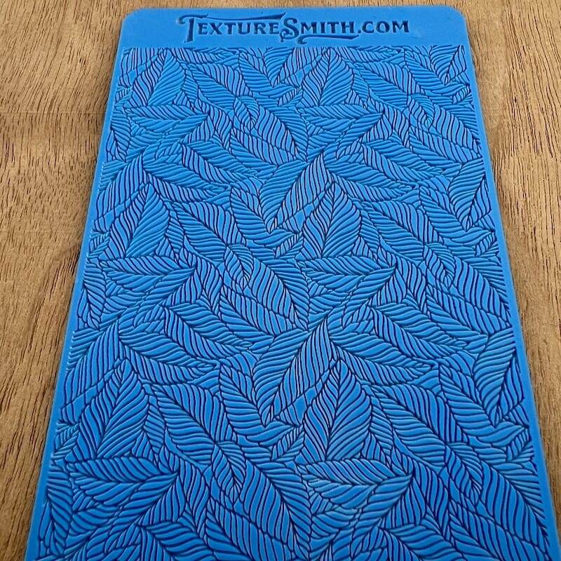 Blue textured mat with intricate leaf patterns.