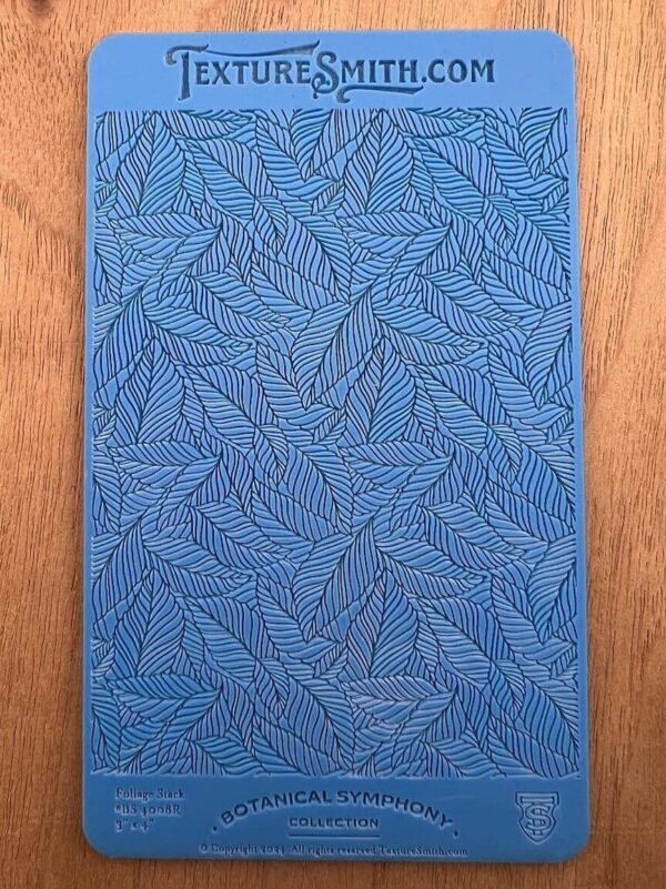 Blue textured surface with intricate leaf-like patterns.