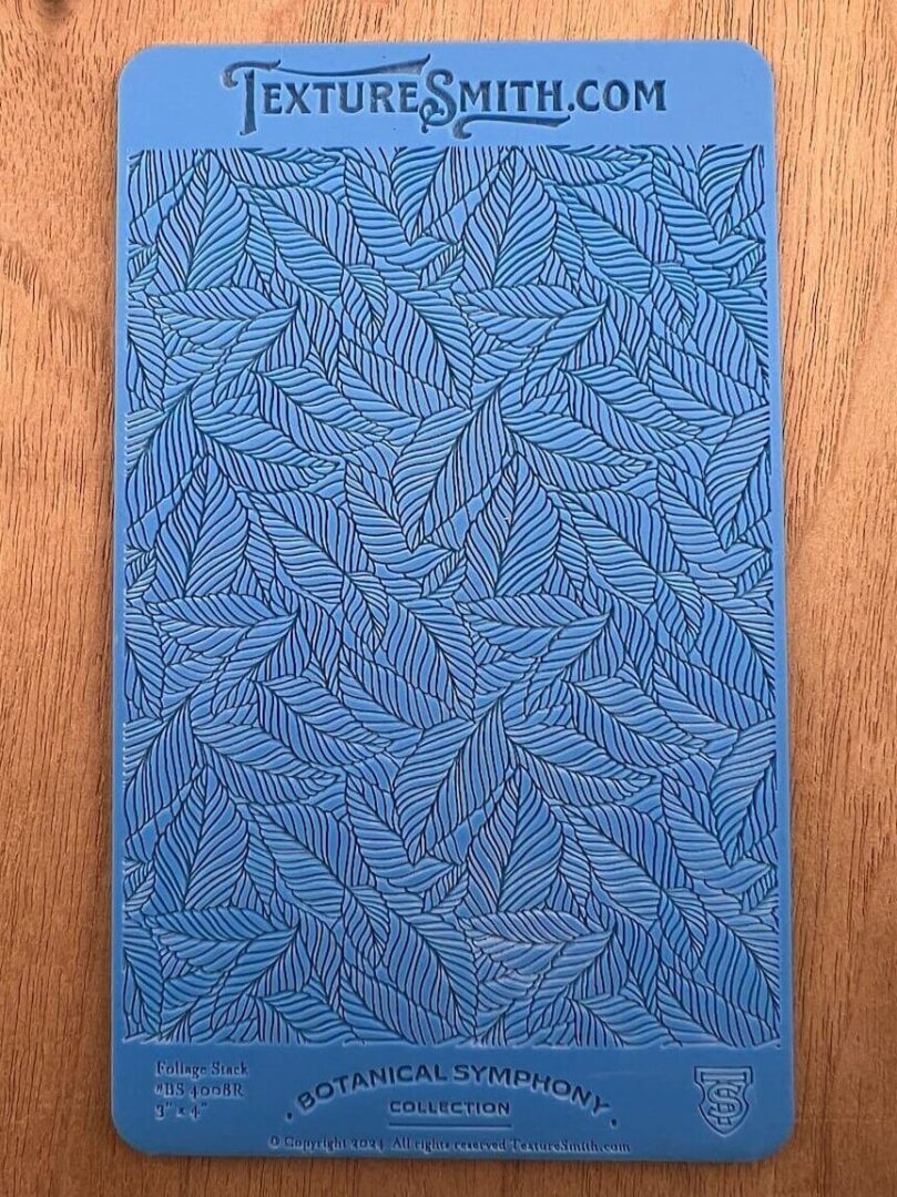Blue textured surface with intricate leaf-like patterns.