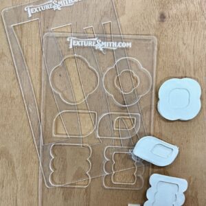 Clear plastic cookie cutters with cloud and flower shapes on a wooden surface.