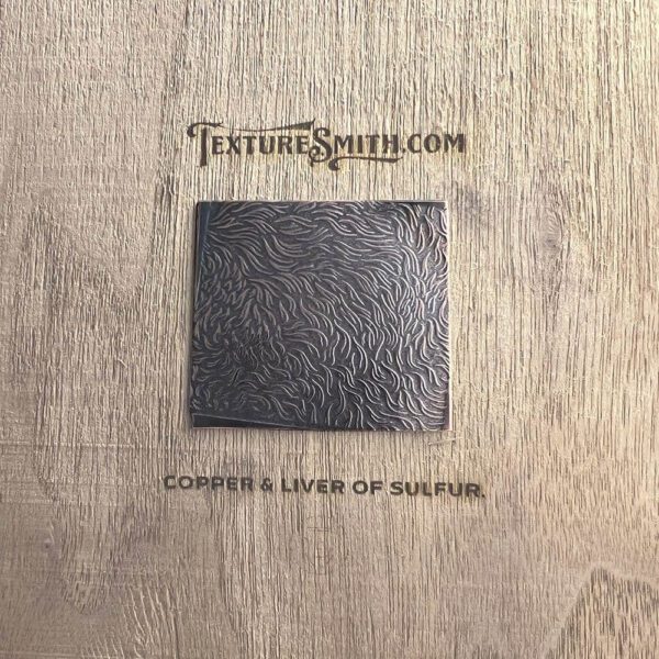 Black square on a wooden textured surface with text above and below it.