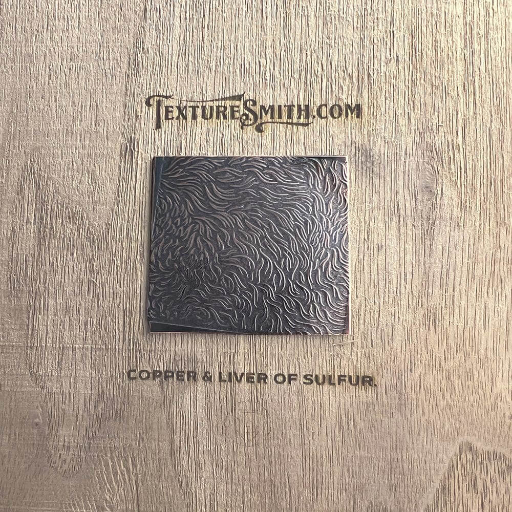 Black square on a wooden textured surface with text above and below it.