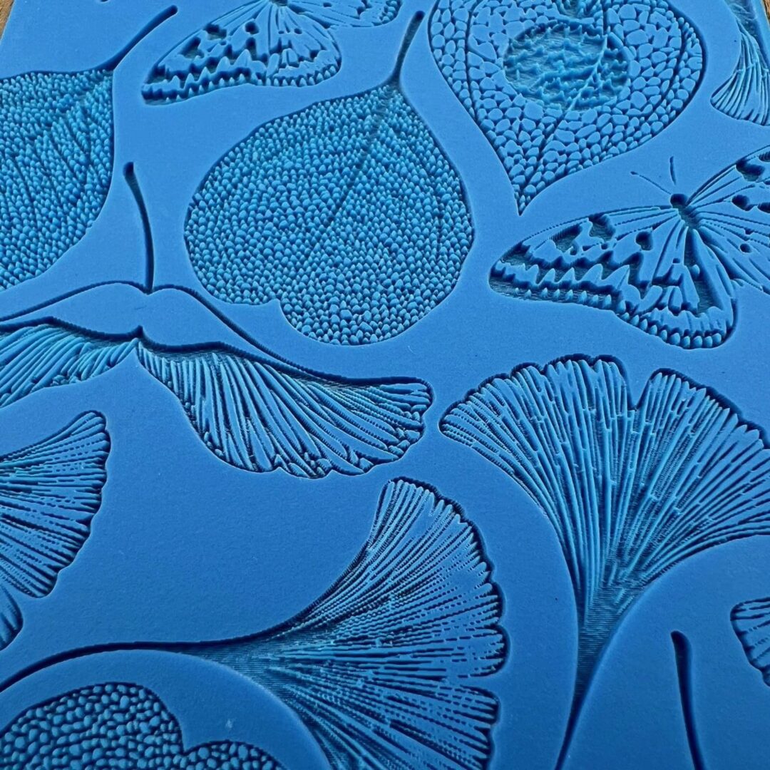 Blue background with detailed black leaf and ginkgo illustrations.