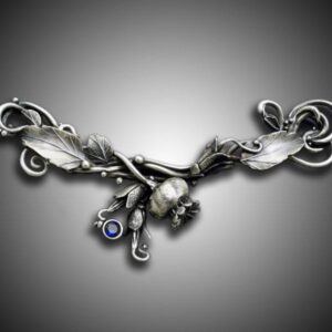 Intricate silver necklace with detailed feather and eye charms.