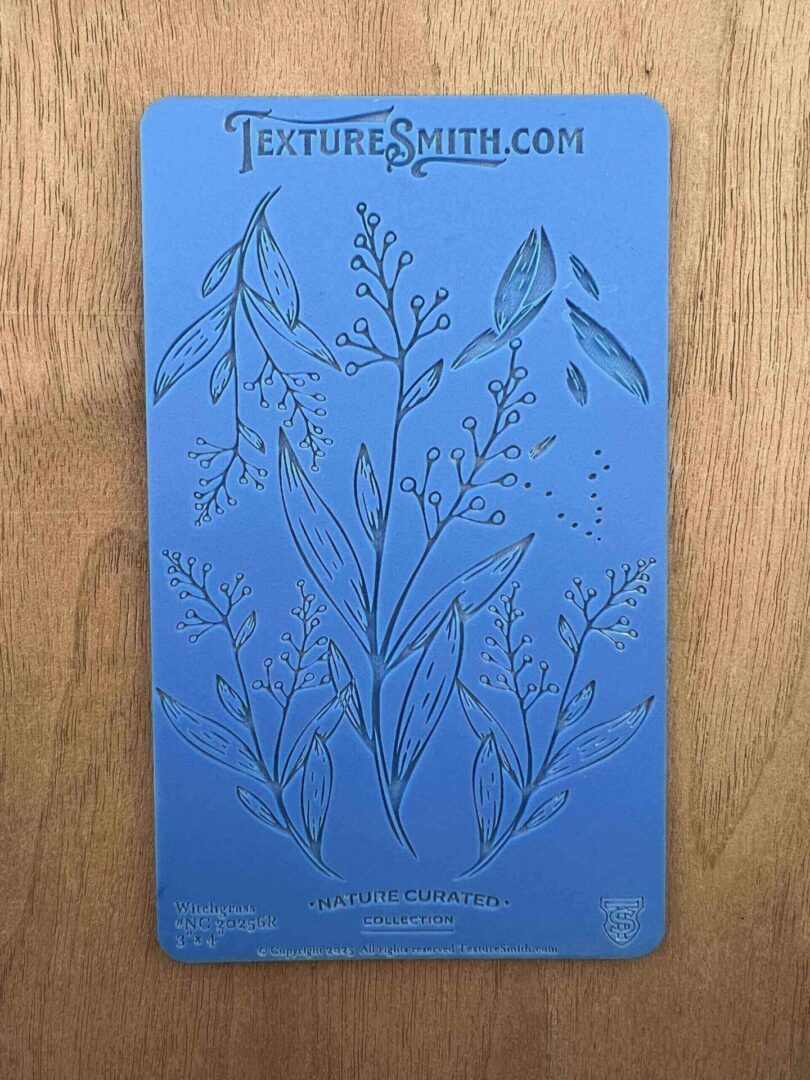 A blue card with botanical illustrations of various plants and herbs.