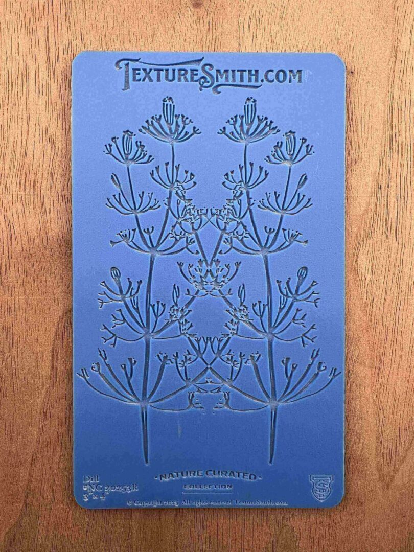 A blue bookmark with an intricate floral design and text at the top.