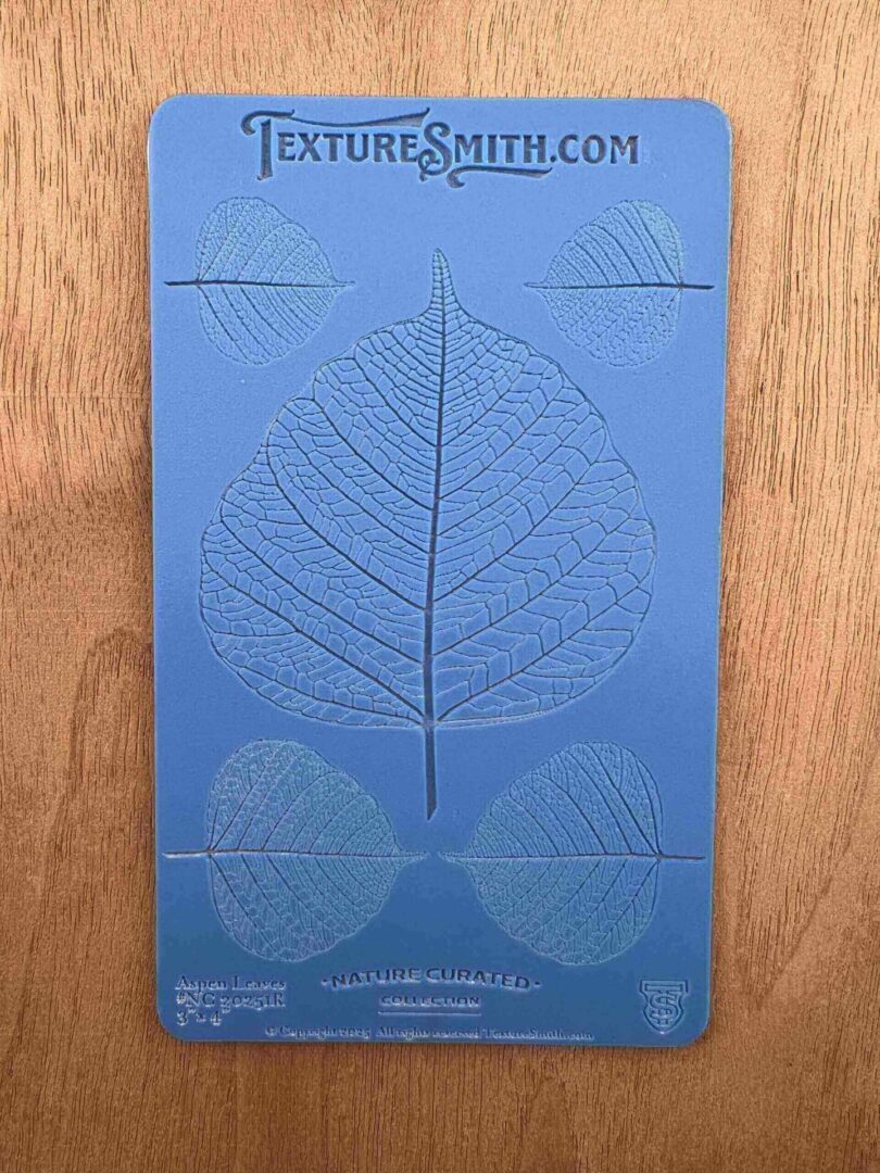 Blue packaging with leaf skeleton design and text on a wooden surface.