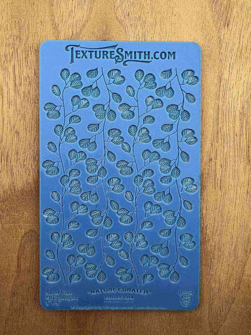 Blue stencil sheet with leafy vine patterns for crafting.