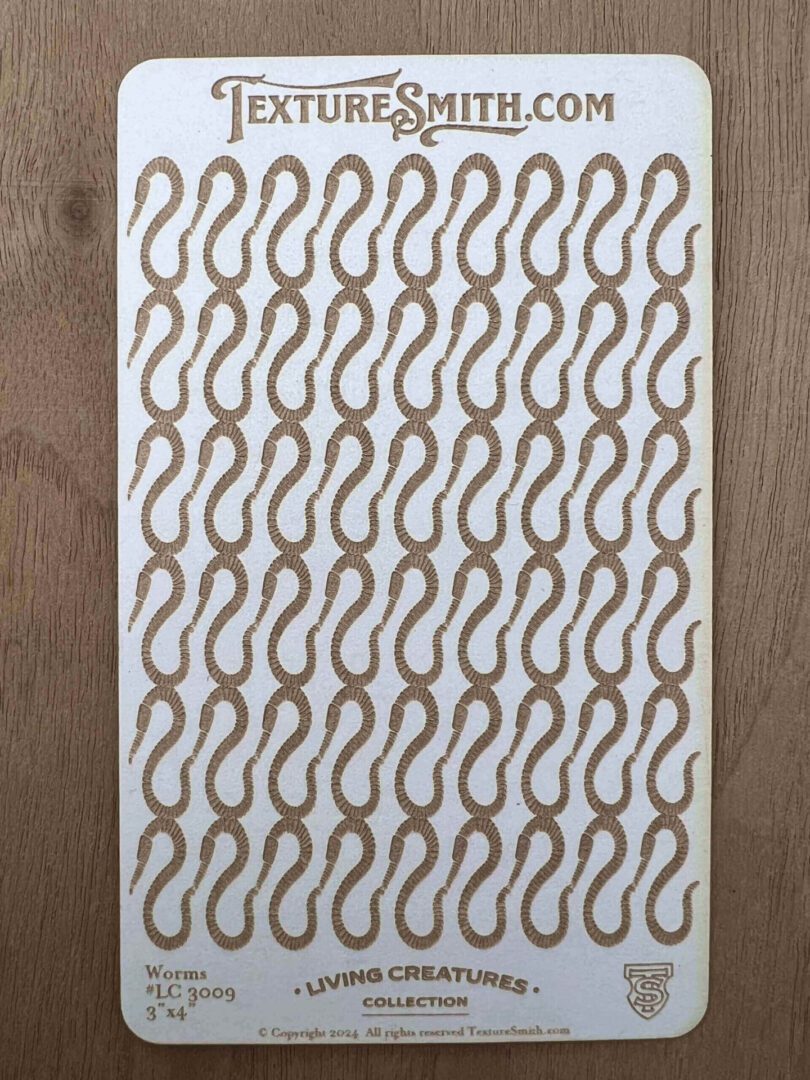 A patterned textile with a repeating paisley design in gray and brown tones.