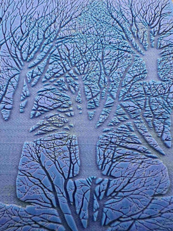 Intricate tree patterns embossed on a blue surface.