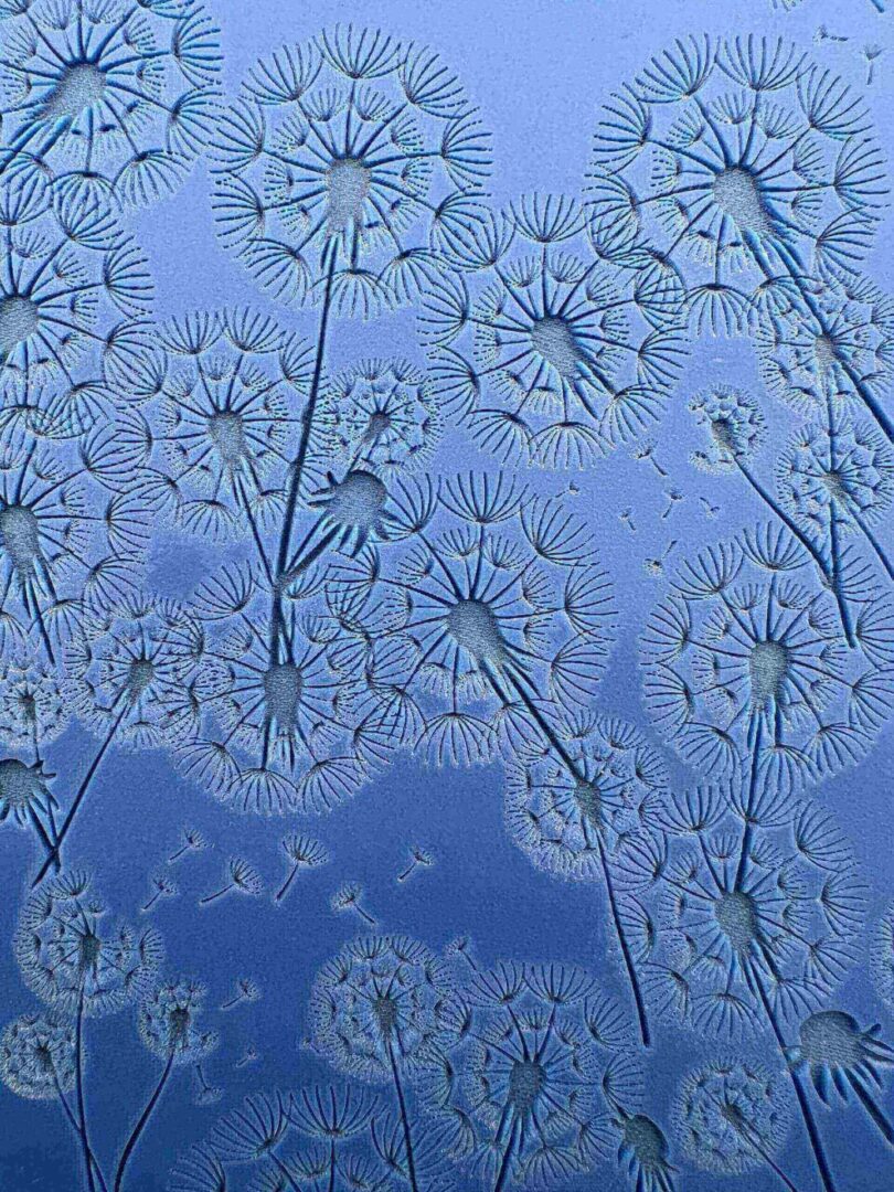 Frost patterns on a window resembling delicate dandelions.
