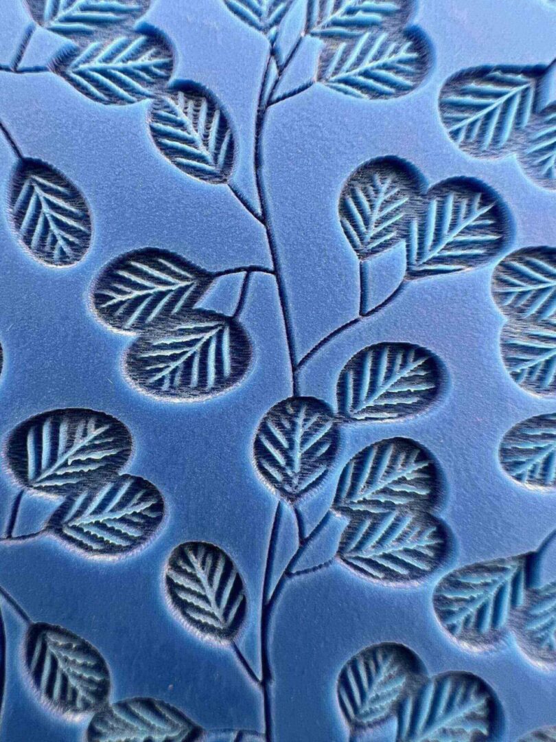 Blue fabric with embossed leaf patterns.