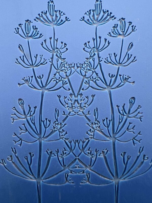 Intricate blue glass artwork with symmetrical floral patterns.