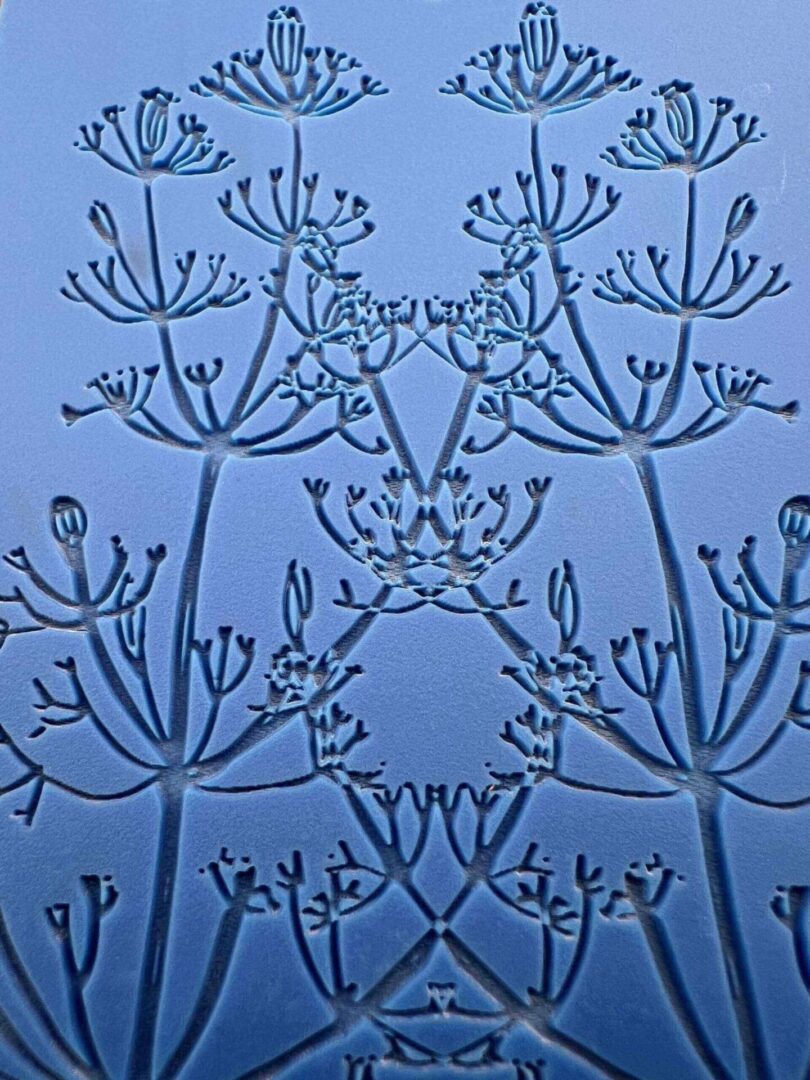 Delicate frost patterns on a blue glass surface.