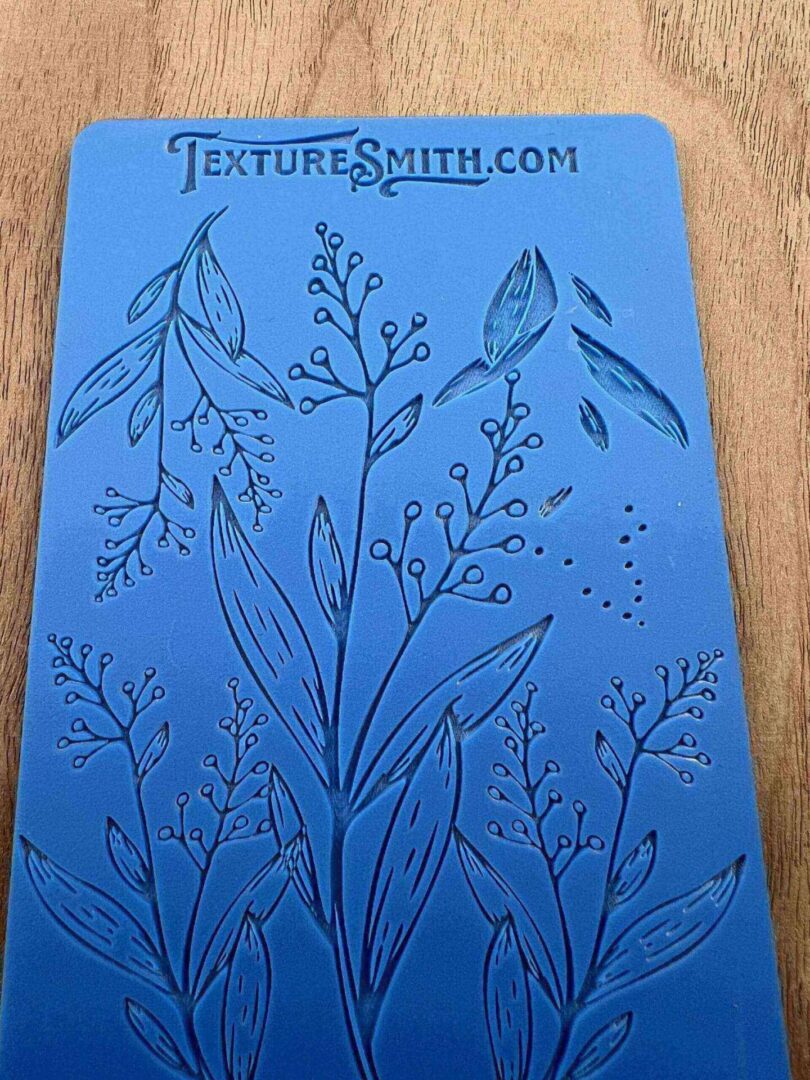 A detailed botanical sketch of various plants and flowers on blue paper.