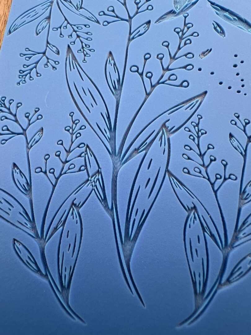 Delicate line art of leafy branches on a blue background.