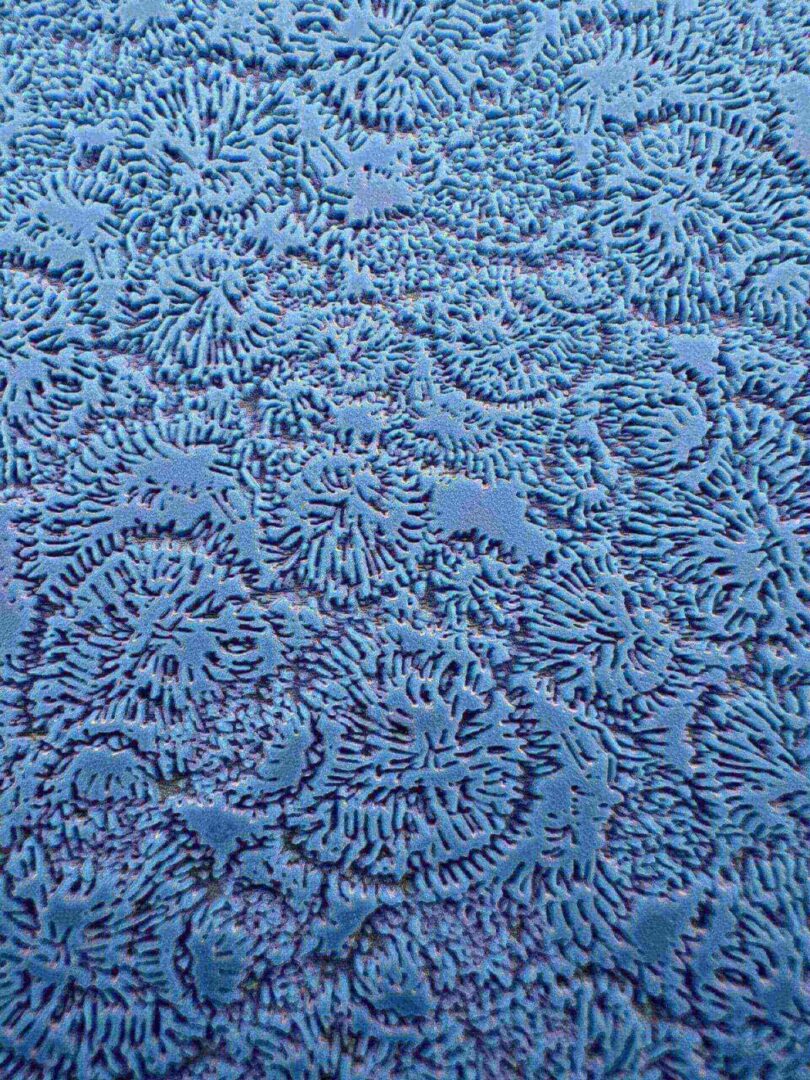 Close-up of blue textured fabric with intricate swirling patterns.