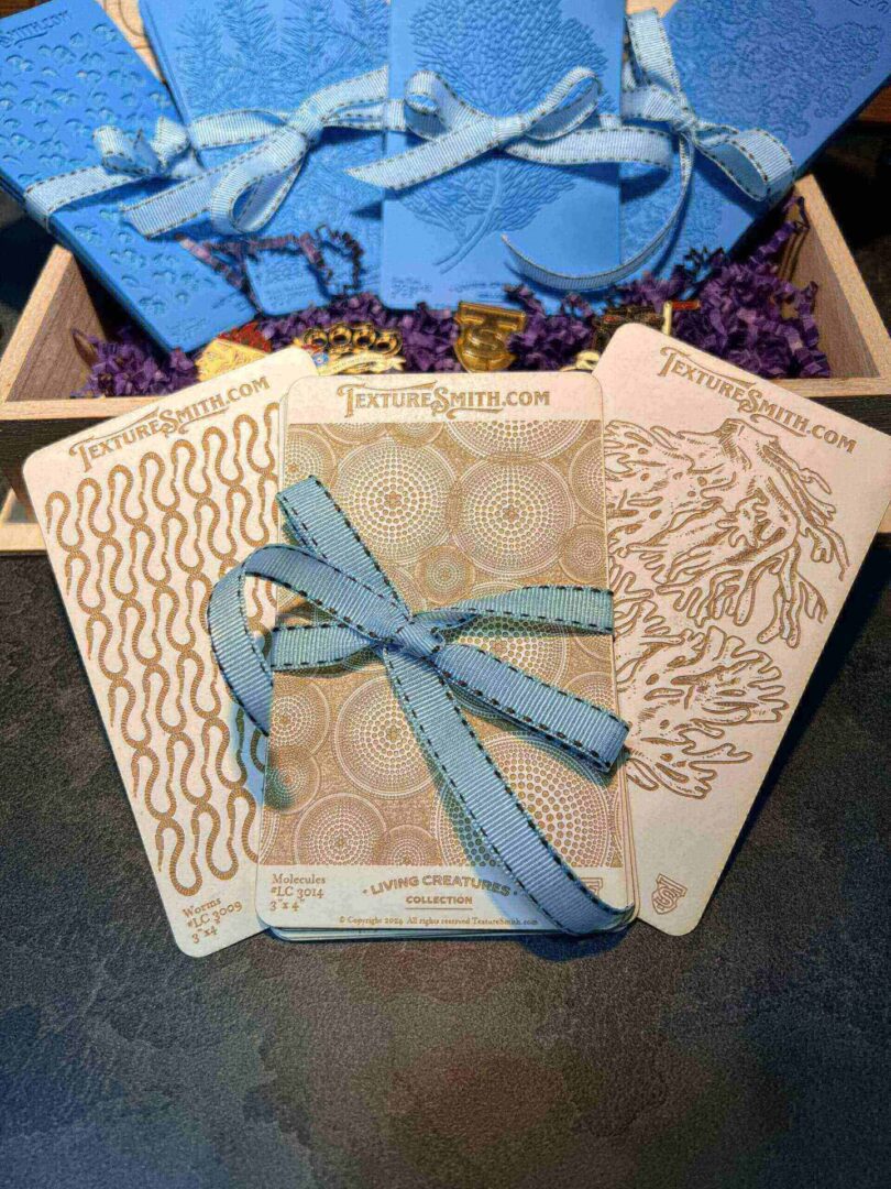 Elegant gift box with a blue ribbon and intricate floral design.