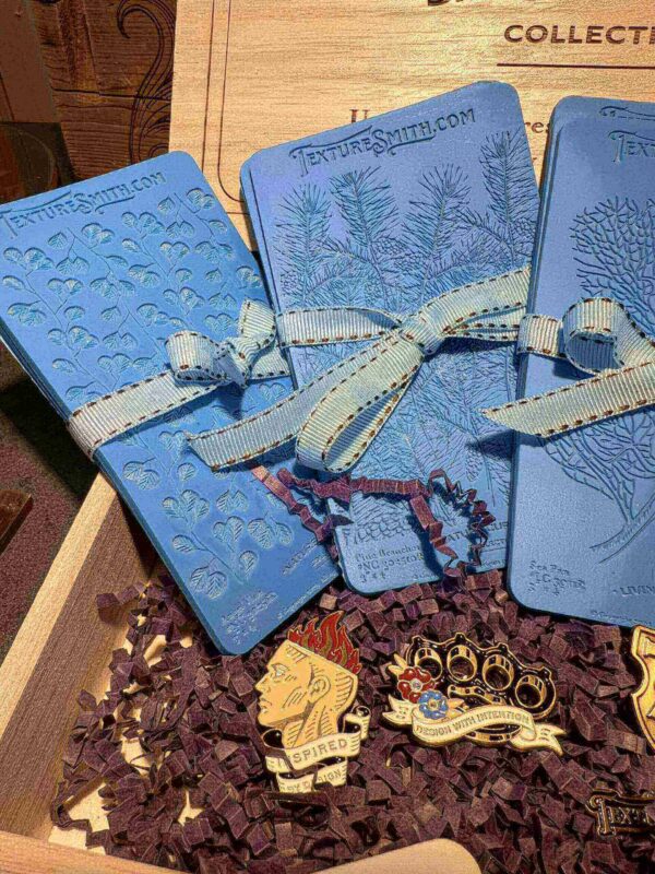 Three blue gift boxes tied with white ribbons on a decorative surface.