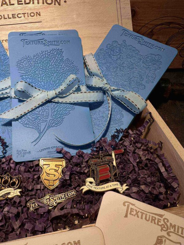 Blue wedding invitations tied with white ribbon on a table.