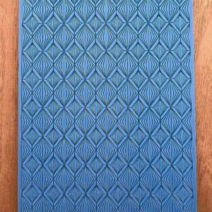 Blue textured mat with diamond patterns on a wooden floor.