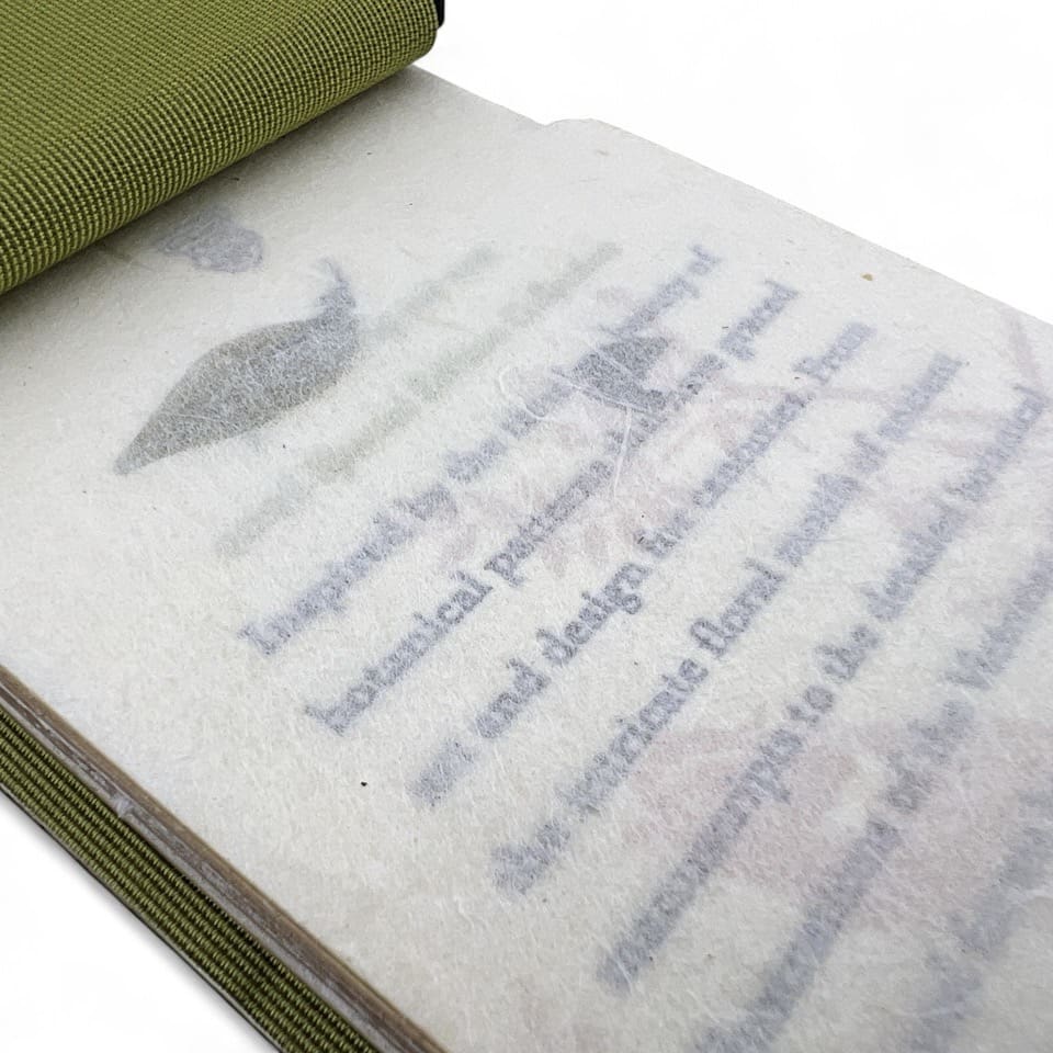 A book page with translucent protective paper partially covering printed text and an illustration.
