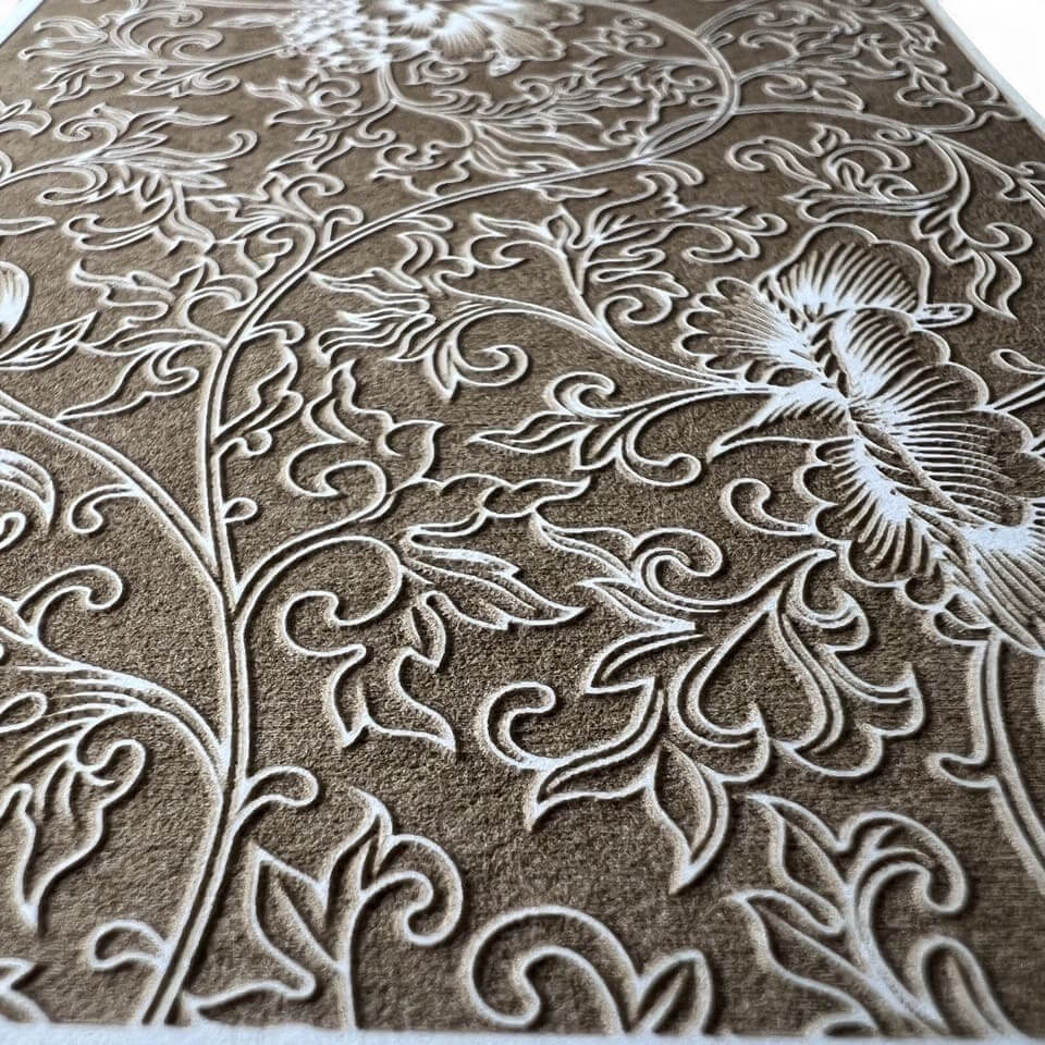 Close-up of an embossed floral pattern on a textured surface.