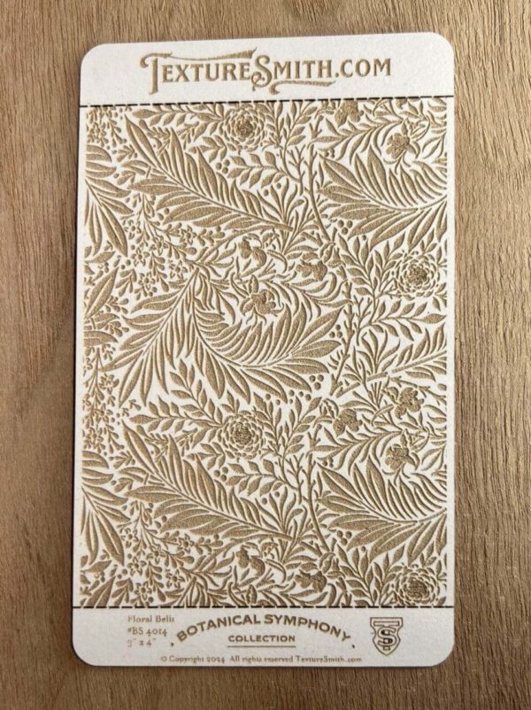 Intricate botanical pattern in beige and white on a wooden surface.