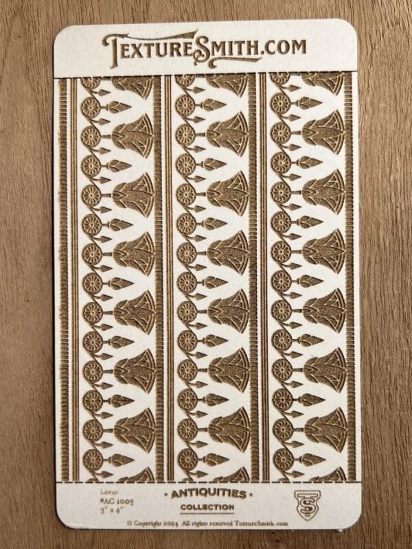 Intricate brown and white patterned fabric strip on wood.