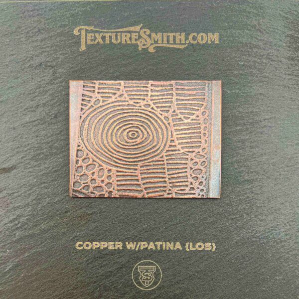 Copper patina metal plate with spiral and geometric designs.