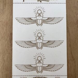 Three hand-drawn Egyptian scarab beetle designs with wings and radiant circles above.