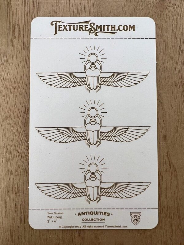 Three hand-drawn Egyptian scarab beetle designs with wings and radiant circles above.