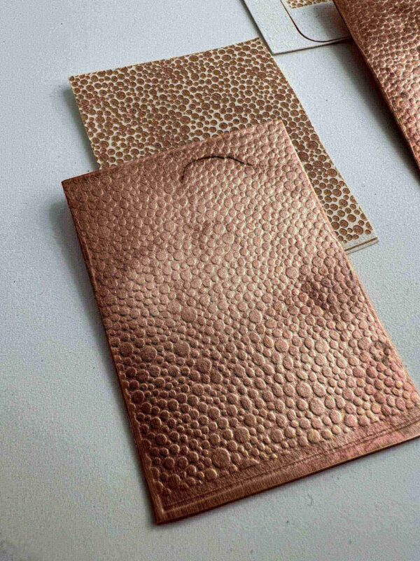 Two textured leather wallets, one brown and one tan, on a gray surface.