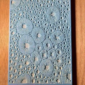 Intricately carved wooden panel with circular patterns.