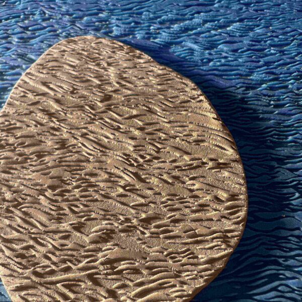 Close-up of a textured, irregularly shaped brown object on a blue surface.