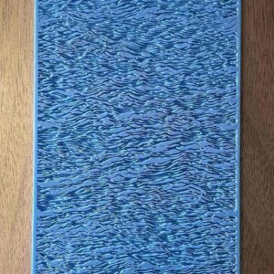 Close-up of a textured blue surface with a wood grain pattern.