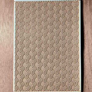 Textured beige fabric with a repeating scallop pattern.