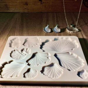 White ceramic plates shaped like seashells on a wooden table.