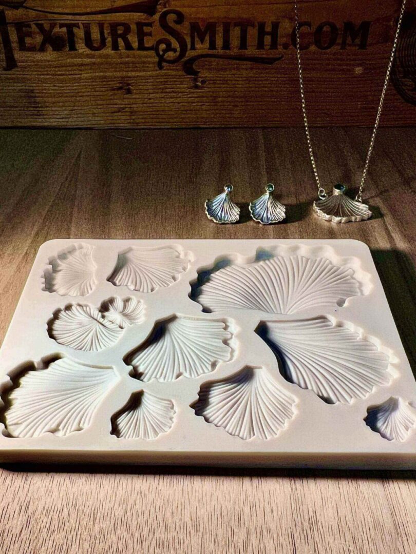 White ceramic plates shaped like seashells on a wooden table.