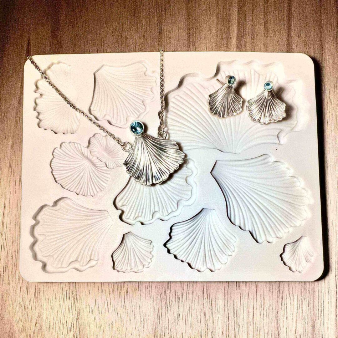 Silicone mold with various leaf and flower shapes on a wooden surface.