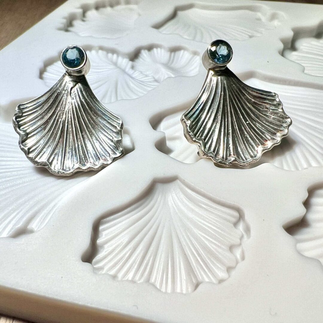 Elegant silver shell-shaped earrings with pearl studs.