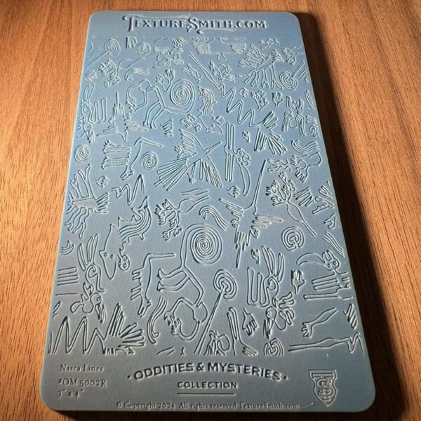 Embossed blue card with detailed floral and bird patterns on wooden surface.