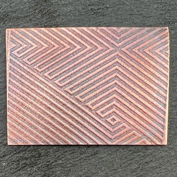 Rectangular tile with geometric line patterns in muted tones.