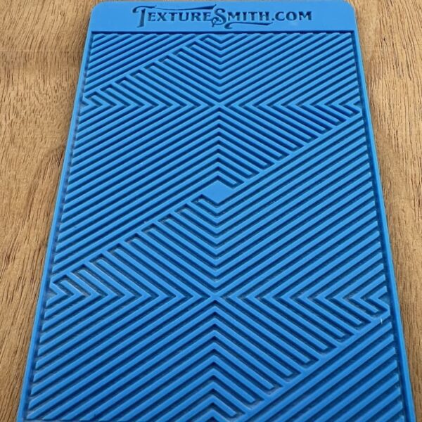 Blue textured mat with geometric patterns on a wooden surface.