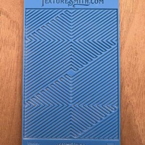 Blue textured panel with geometric patterns on a wooden surface.