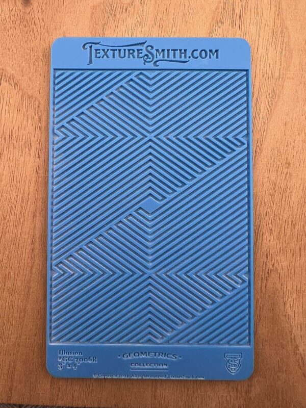 Blue textured panel with geometric patterns on a wooden surface.