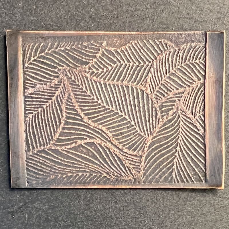 Rectangular wooden tray with carved leaf patterns.