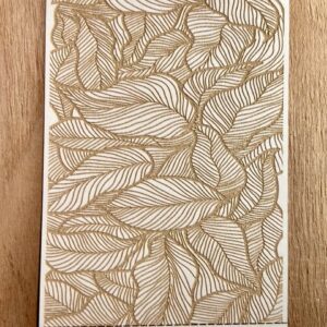 Intricate leaf pattern etched on wooden surface.