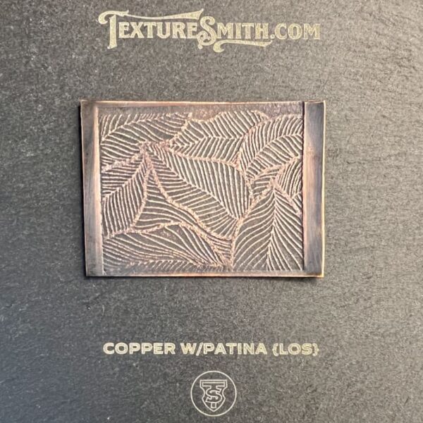 Copper panel with patina displaying an intricate leaf design.
