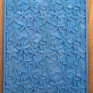 Blue textured wall art with starfish patterns framed in wood.